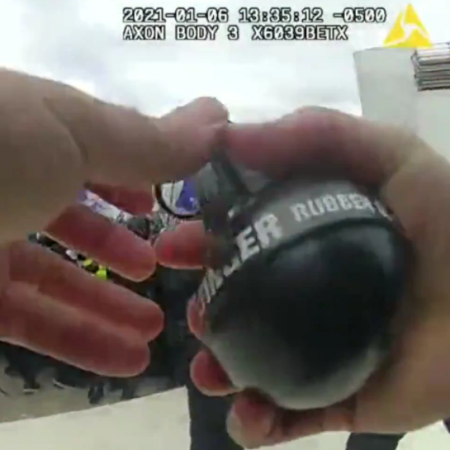 Screen capture from bodycam of officer, preparing grenade to throw into crowd