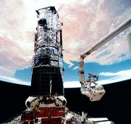 Story Musgrave on the shuttle robot arm during the last spacewalk of the 1993 Hubble repair mission